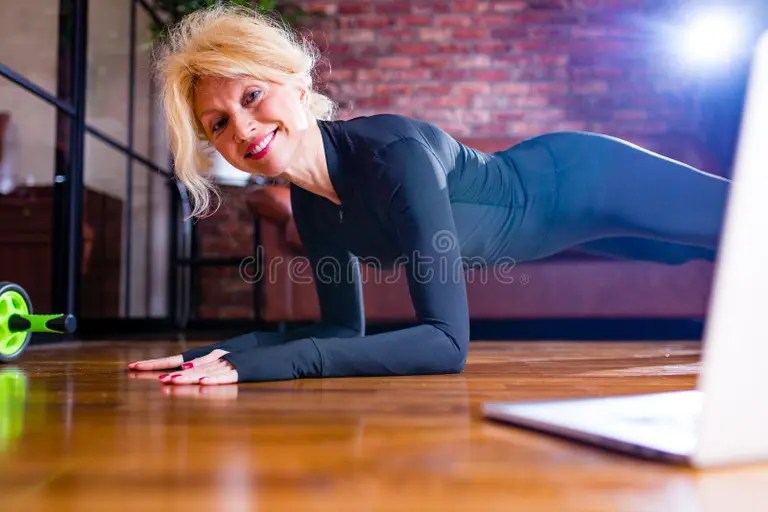 Woman holding elbow plank during home workout.
