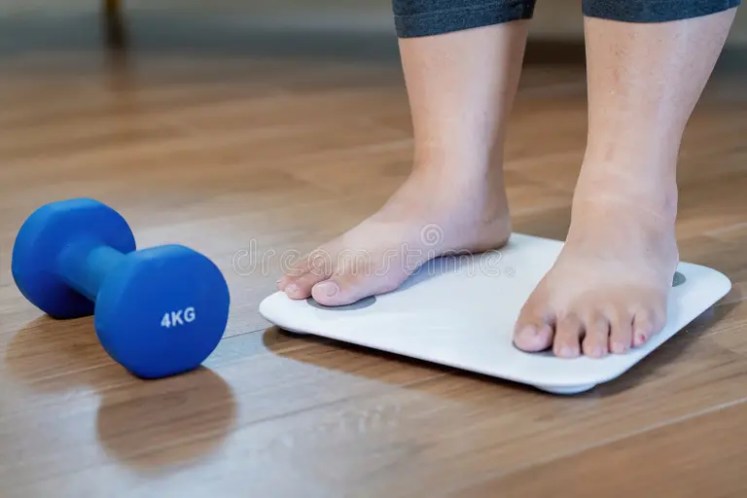 Overweight Woman Weighing Herself On A Scale.