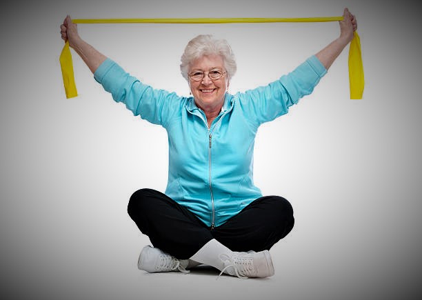 Active adult performing overhead exercise with band.